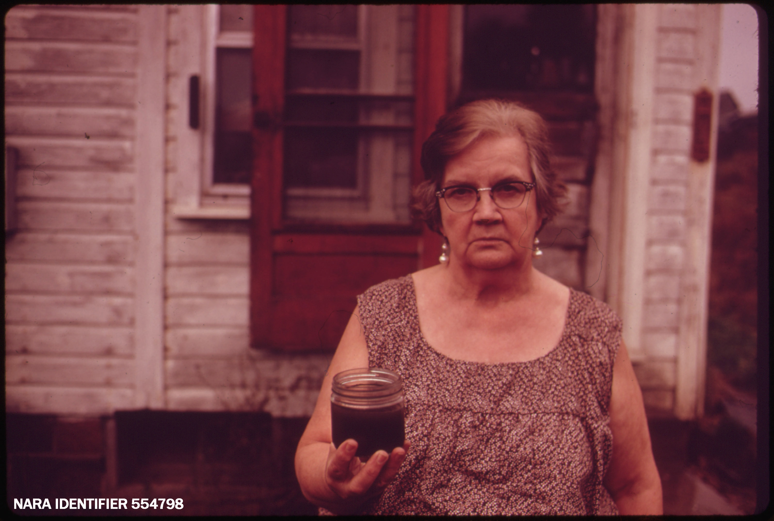 Landscape Mary Workman holds a jar of undrinkable water...