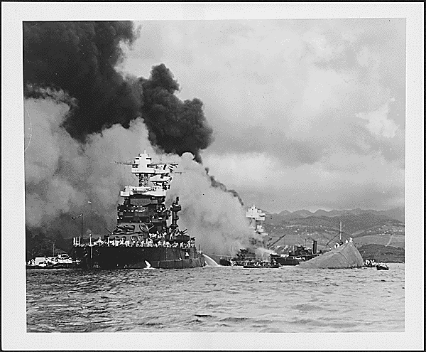 Photograph of the capsized USS Oklahoma and a slightly damaged USS Maryland, 12/07/1941