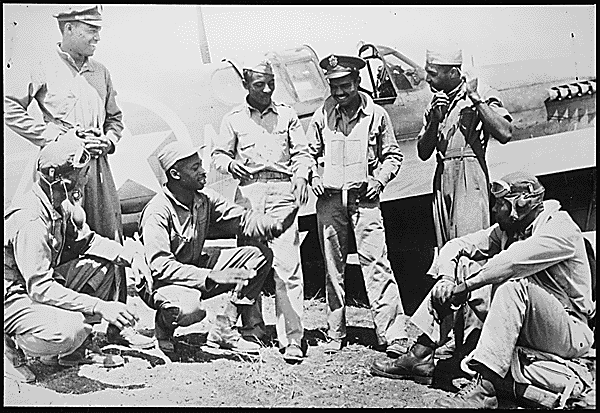 "Pilots of a U.S. Army Air Forces fighter squadron, credited with shooting down 8 of the 28 German planes destroyed in dogfights over the new Allied beachheads south of Rome, on Jan. 27, talk over the day's exploits at a U.S. base in the Mediterranean theater. Negro members of this squadron, veterans of the North African and Sicilian campaigns, were formerly classmates at a university in the southern U.S.", 02/1944