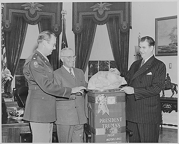 Photograph of Sen. Olin Johnston of South Carolina presenting President Truman with a turkey from Wilton E. Hall of Anderson, South Carolina, as Colonel Lewis Jackson looks on., 11/25/1946 12-0755a